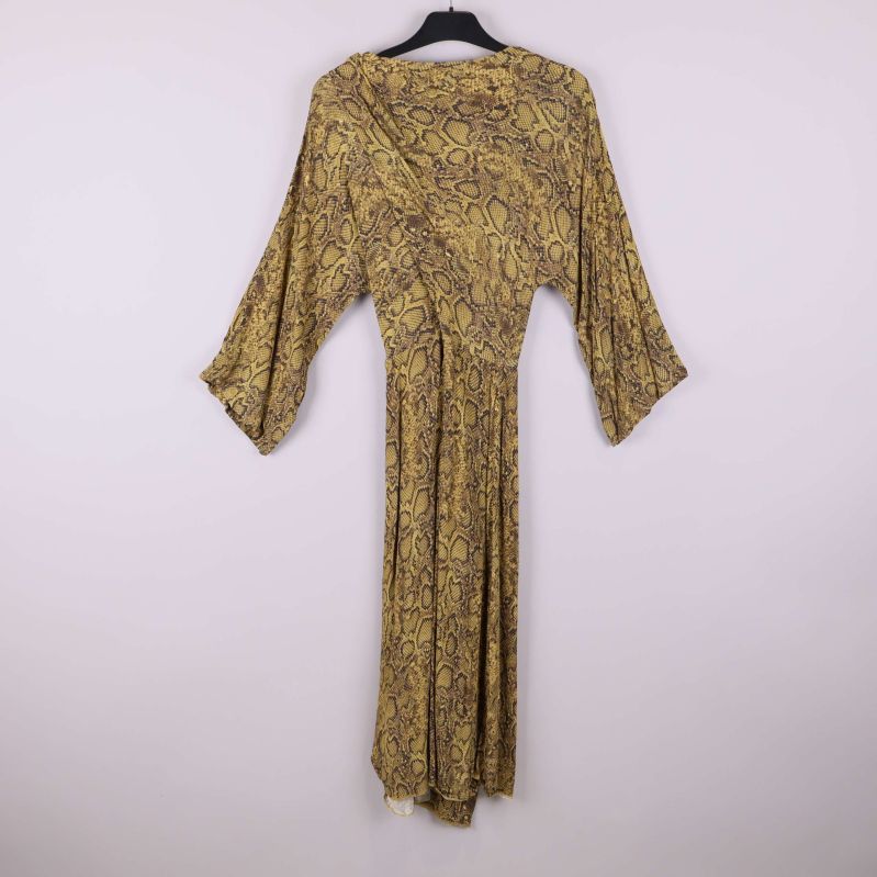 Baksidan av lång klänning med ormmönster och vida ärmar