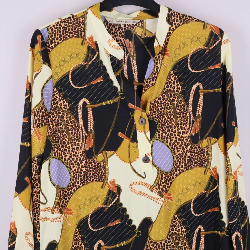 Närbild på tunikans överdel och knappar framtill