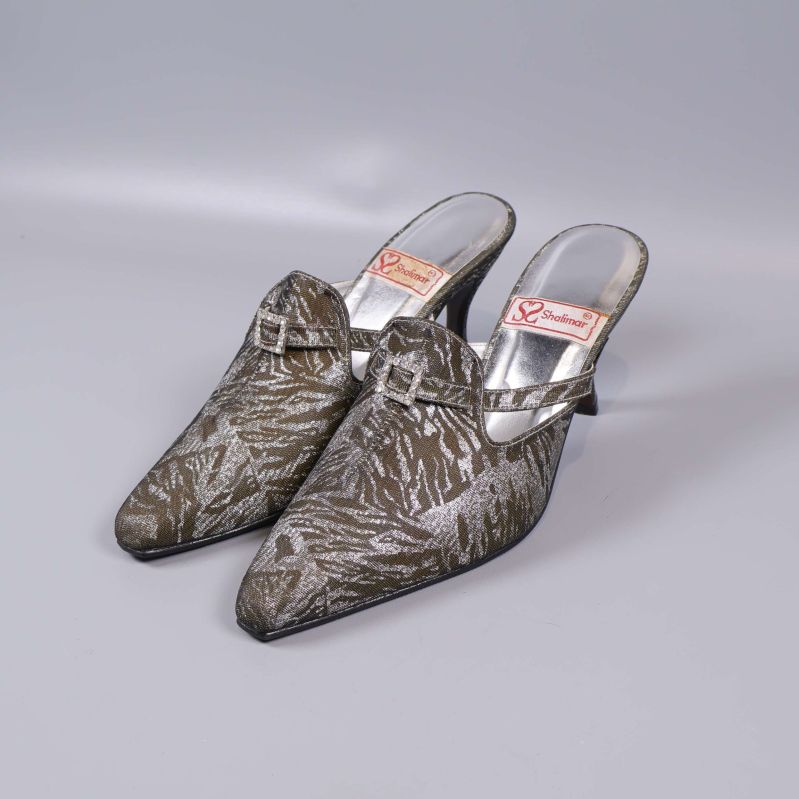 Klackskor med metallicmönster och spänne snett framifrån