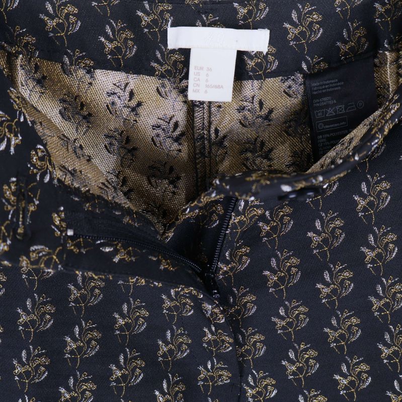 Närbild på linning och dragkedja samt etiketter