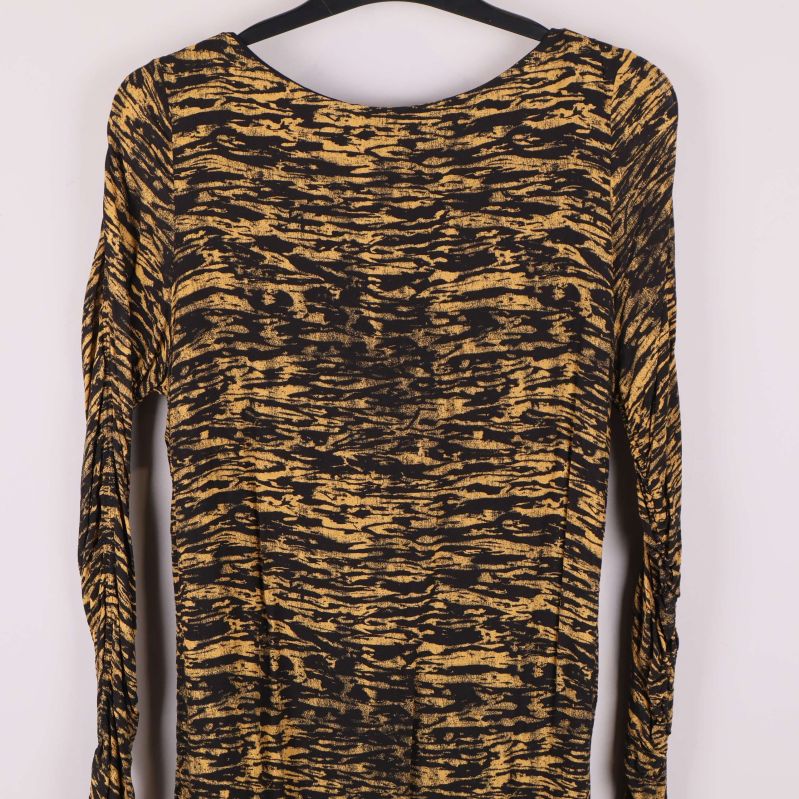 Framstycke av långärmad klänning med abstrakt mönster