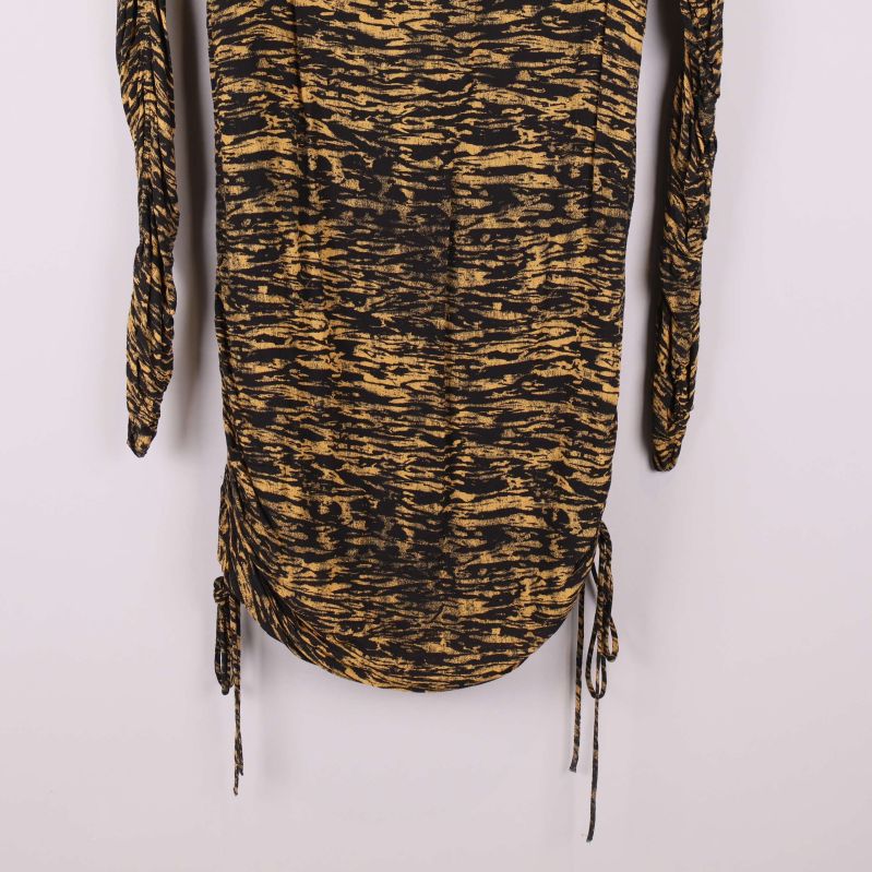 Dragsko och detalj av klännings nederkant, svart och gult tyg