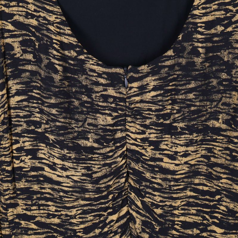 Närbild av ryggparti och tygstruktur på klänning