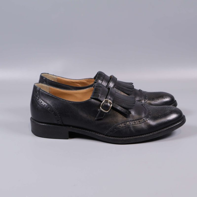 Svarta loafers med låg klack sedd från sidan