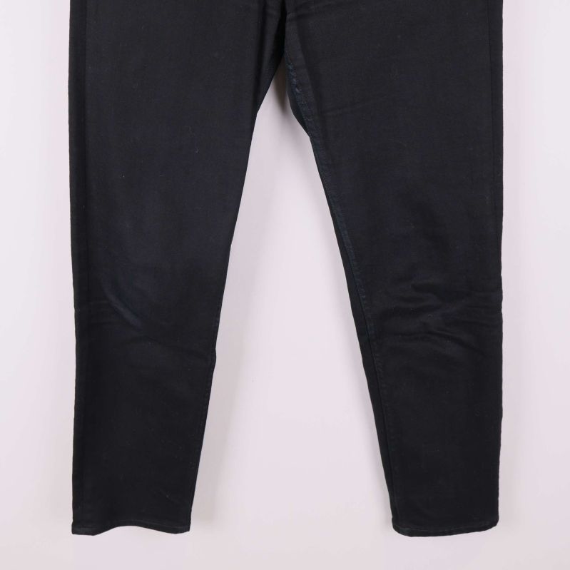 Närbild på benen av svarta jeans utan synlig dekoration