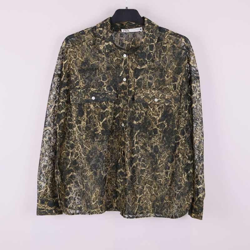 Framsidan av transparent skjorta med svart och guld mönster