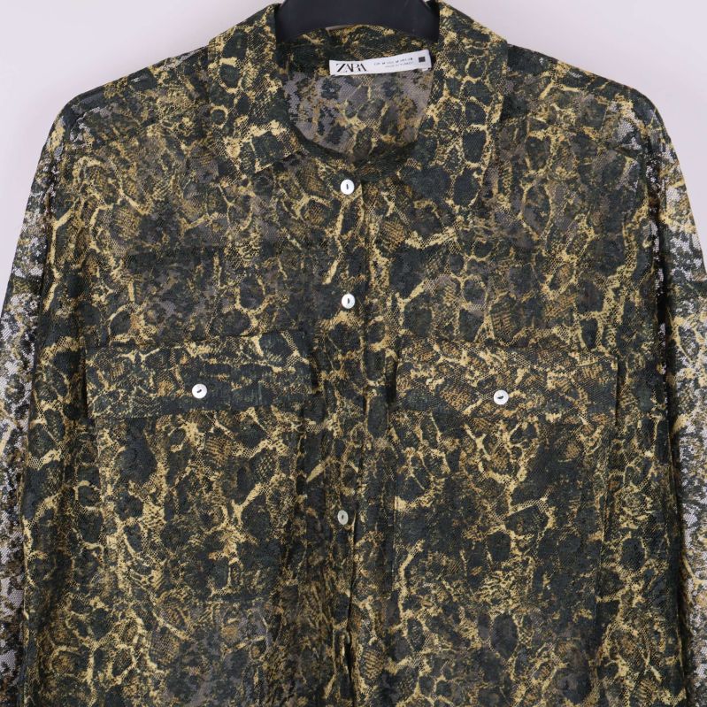 Detaljbild på bröstfickor och knappar på mönstrad skjorta