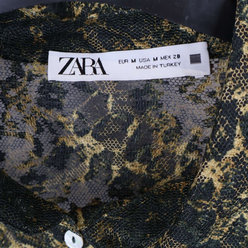 Närbild på ZARA-etikett i skjortans krage