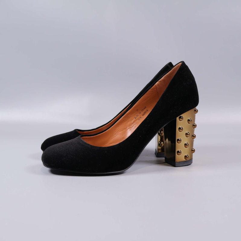 Svarta pumps från sidan båda skorna med gulddetaljer