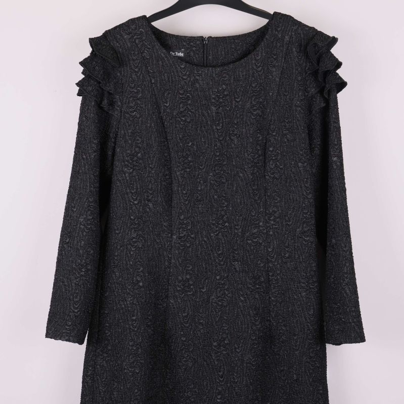 Närbild på klänningens övre del och axeldetaljer