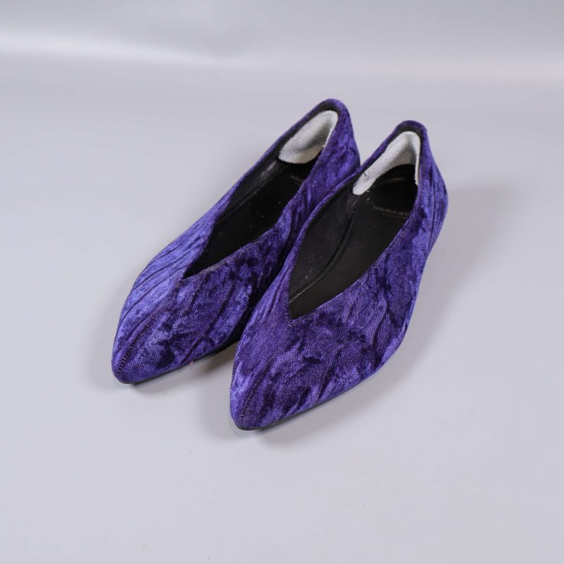 Par lila sammetsballerinor från sned vinkel