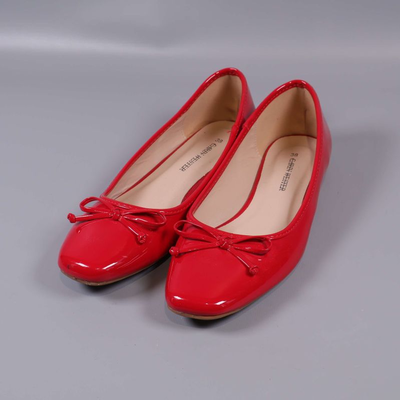 Röda ballerinas med rosett på neutralt underlag