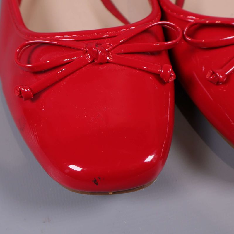 Närbild framdel röda ballerinaskor med rosett och småmärken