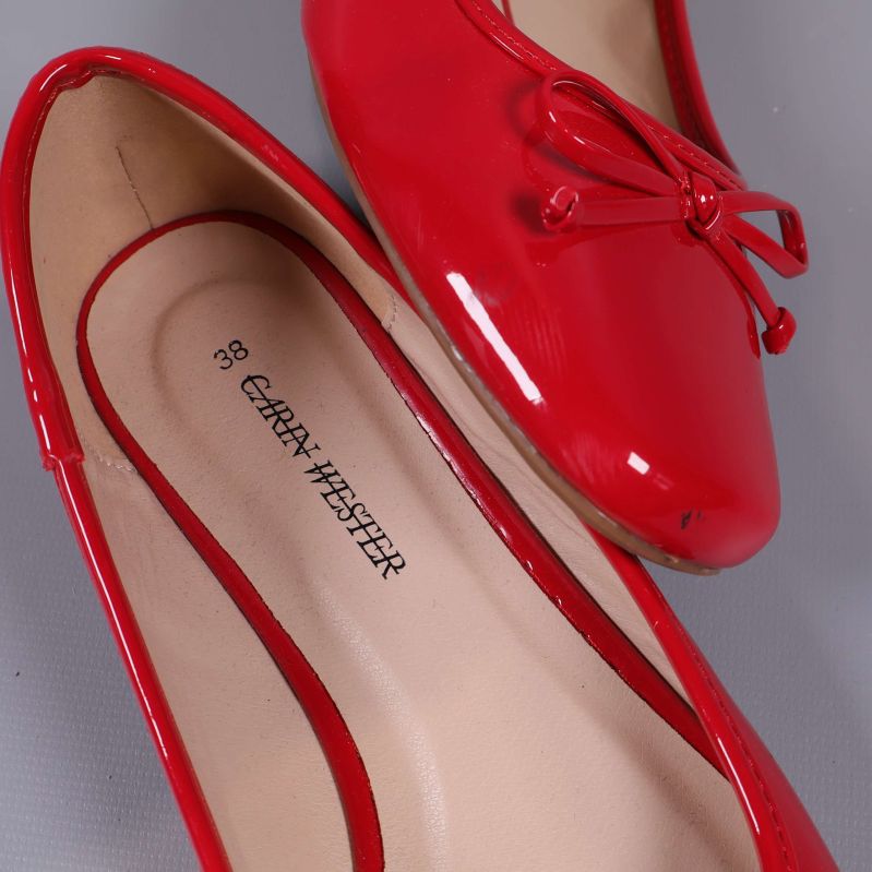 Röda ballerinas ovanifrån, text Grant Hester syns i innersulan