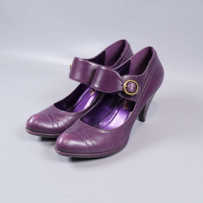 Par lila klackskor med spänne, sedd snett framifrån