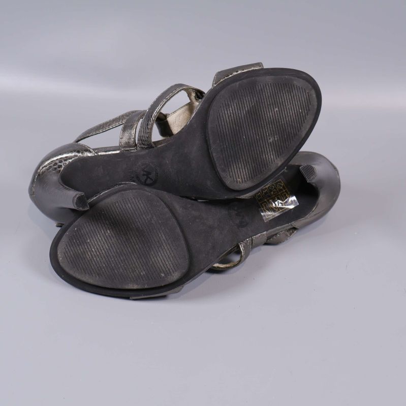 Sandalerna undersida med synliga sulor och slitage