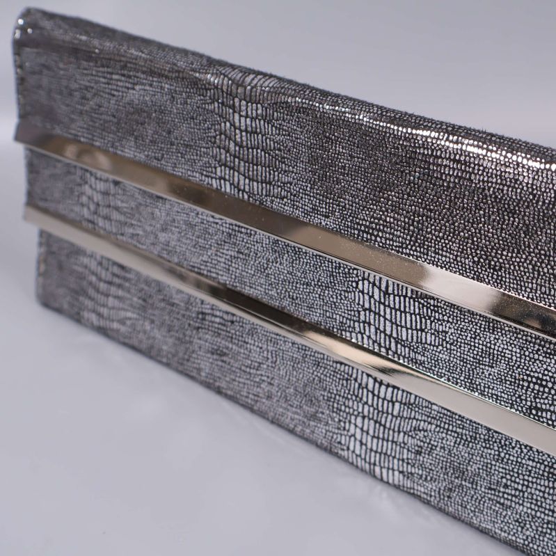 Närbild på strukturerad yta och metallband på clutch