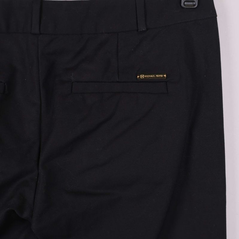 Närbild på bakfickor och Michael Kors-märkesbricka