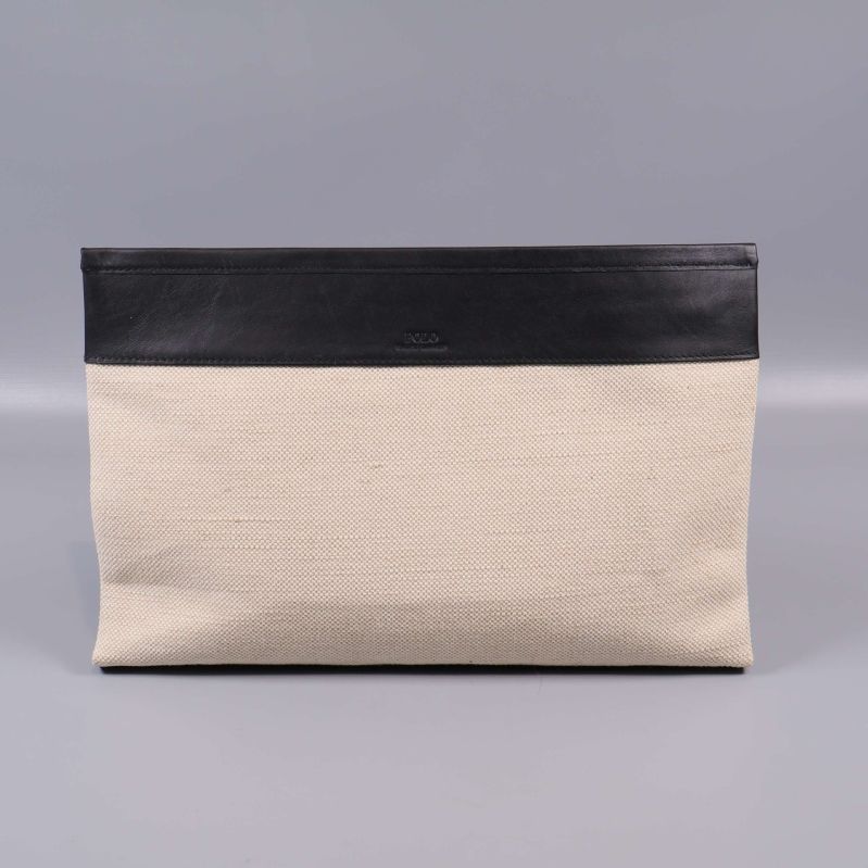 Clutchens baksida i beige canvas och svart kant