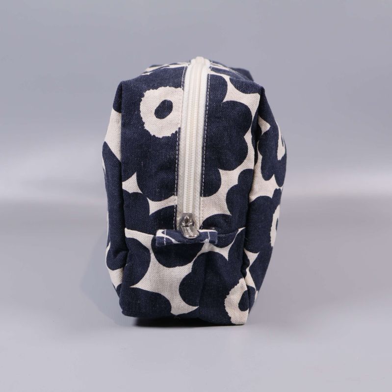 Sidovy på necessär med blommigt tyg och dragkedja upptill