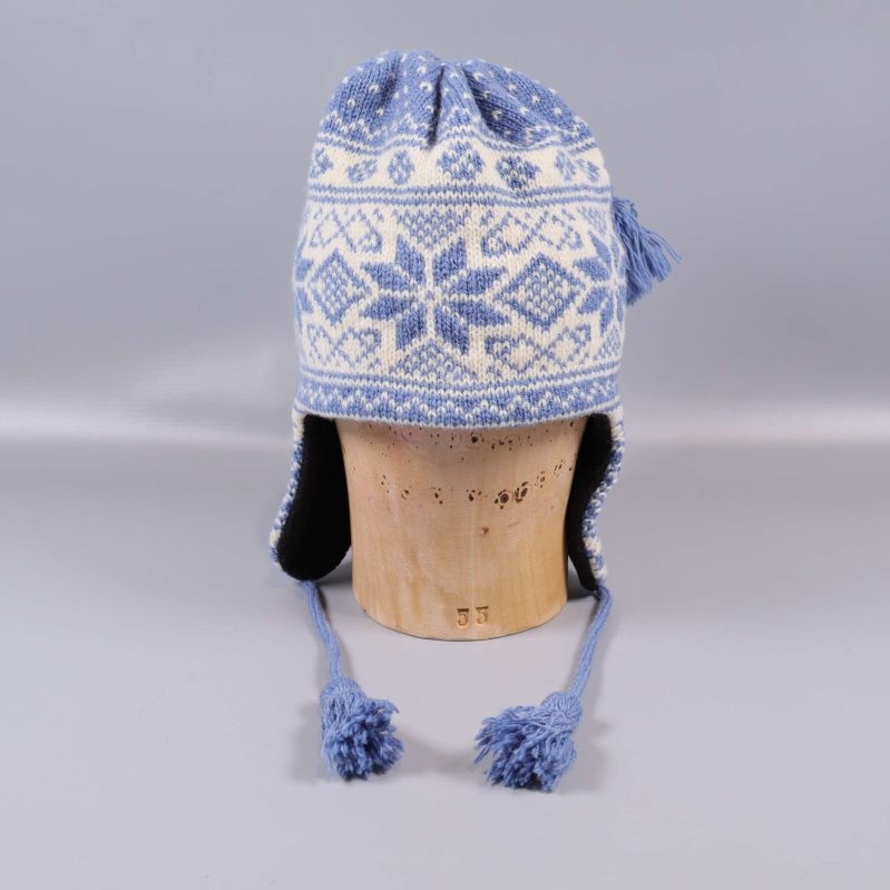 Baksida på stickad mössa med långa öronklappar och tofsar