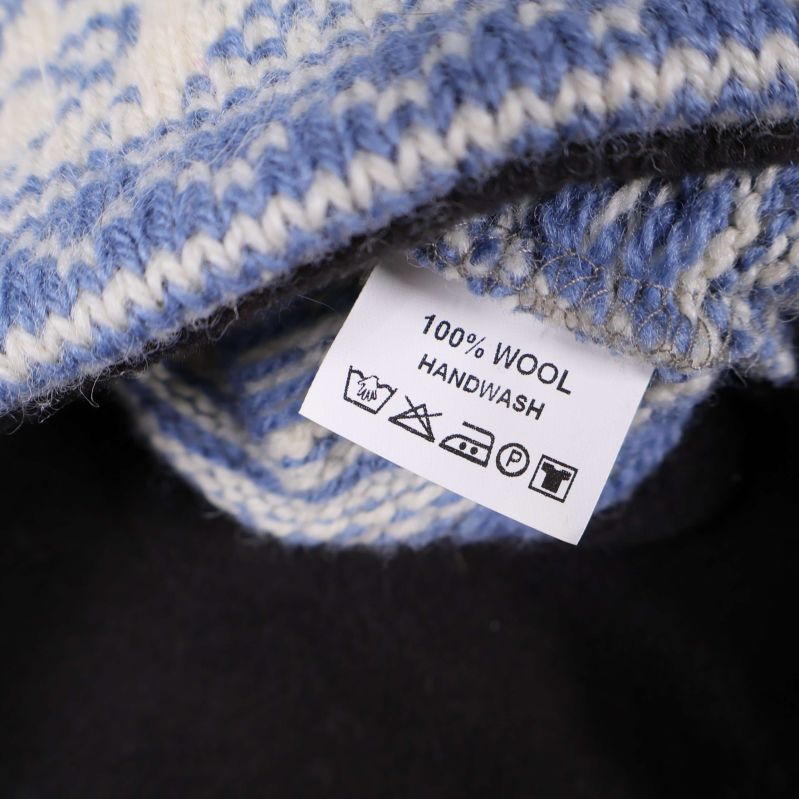 Närbild på etikett visar 100% ull och tvättråd