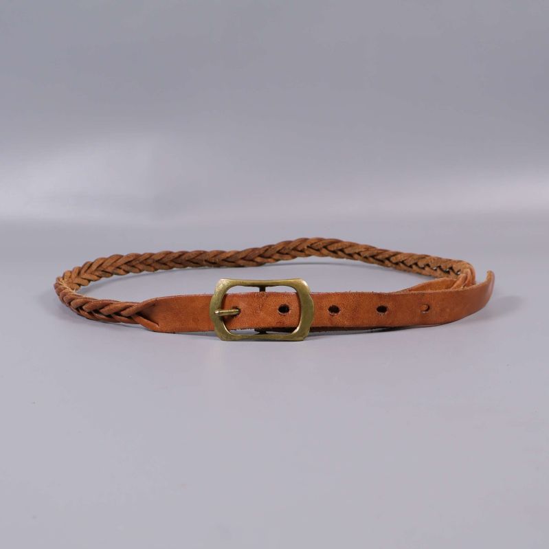 Brunt flätat bälte med mässingsspänne mot grå bakgrund