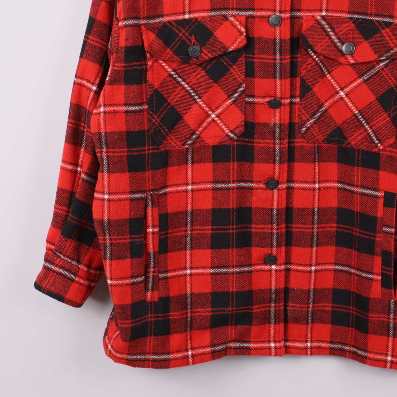 Närbild på undre delen av röd-rutig skjortjacka med fickor