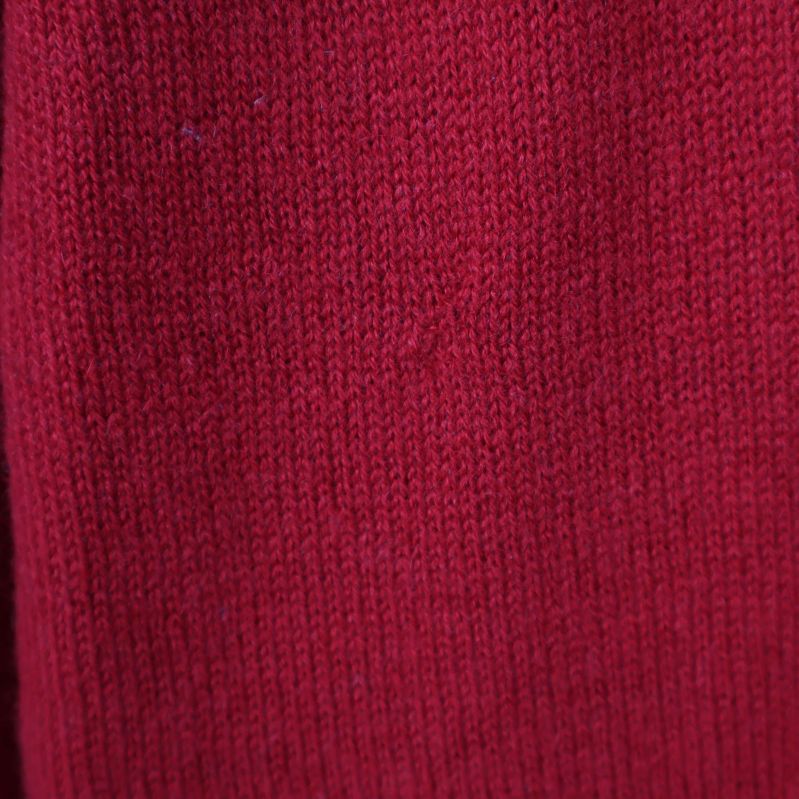Materialstruktur på röd stickad tröja i närbild