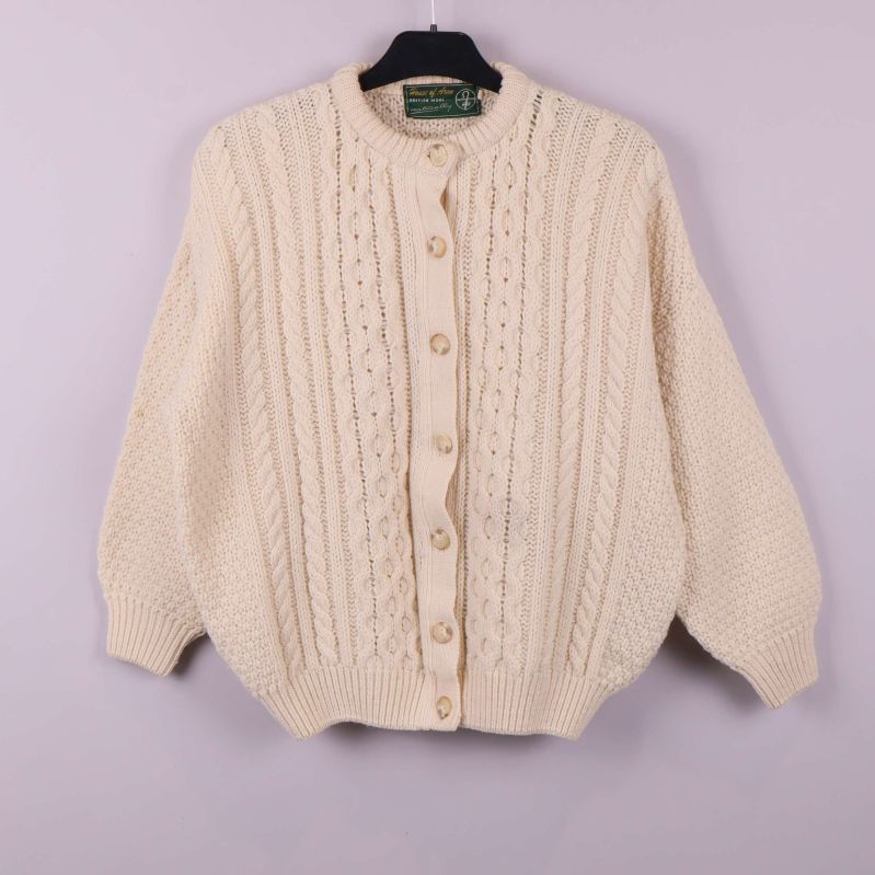 Framsida av grovstickad kofta med kabelmönster och knappar