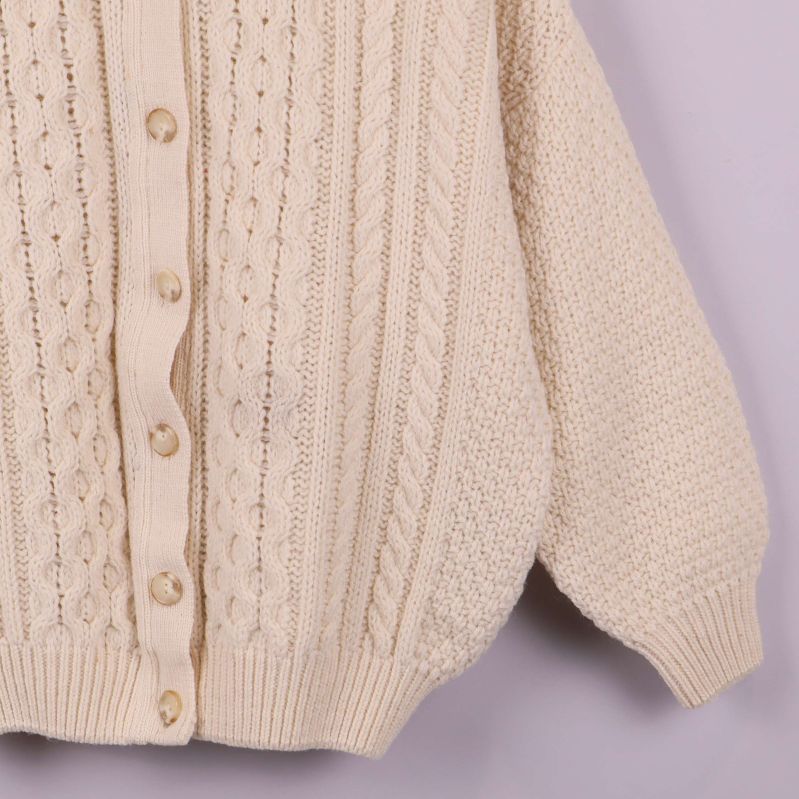 Närbild på sida med ficka och kabelmönster på koftan