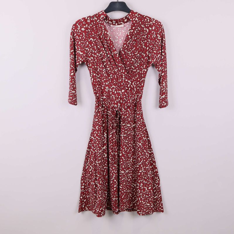 Röd klänning med vita stjärnor på galge framifrån