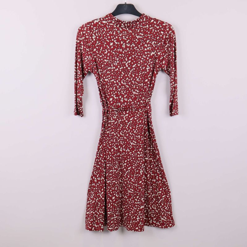 Röd klänning med stjärnmönster på galge bakifrån