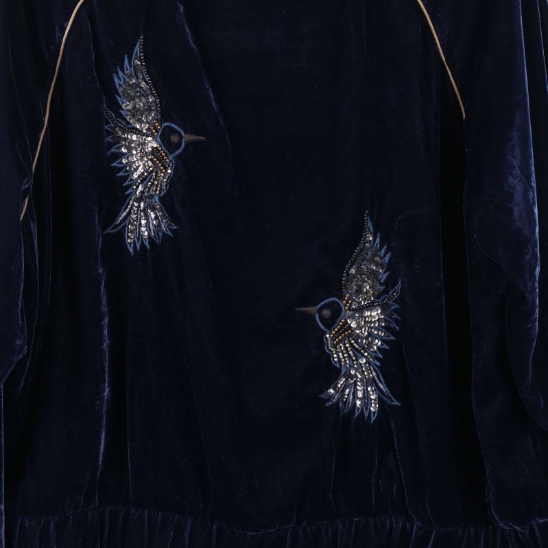 Närbild på broderade fåglar på jackans baksida