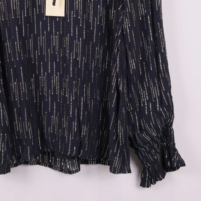 Närbild på blusens volangkant vid ärmslutet