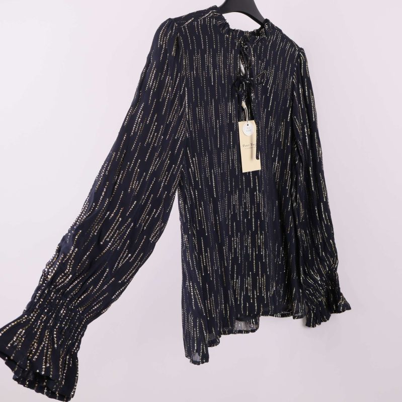 Blus med långa volangärmar i sidovy på galge