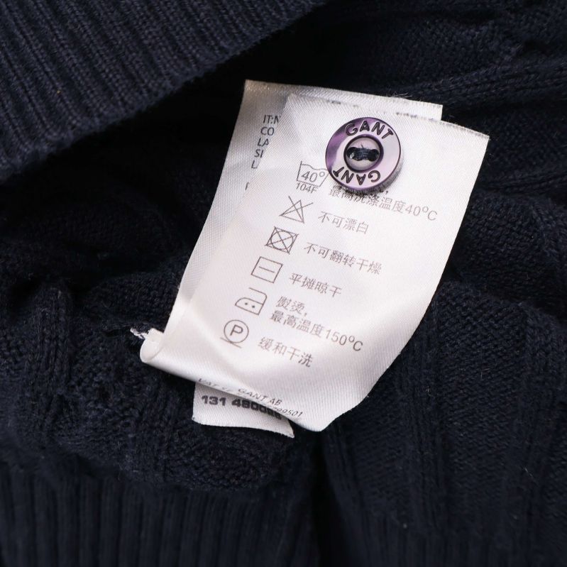 Tvättanvisningar och skötselråd på etikett inuti cardigan