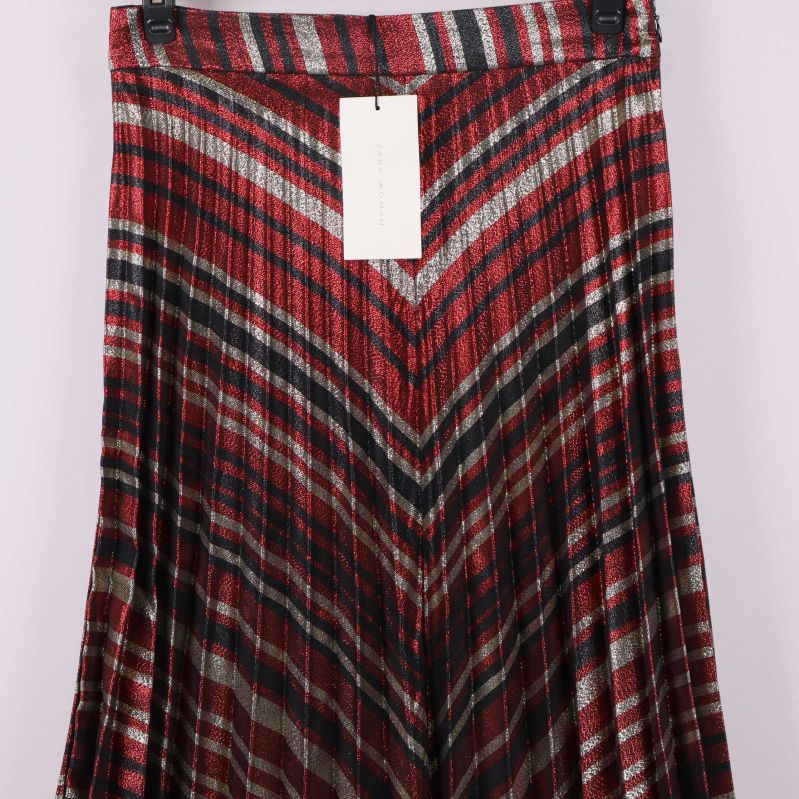 Närbild på v-format mönster och plissering på kjol