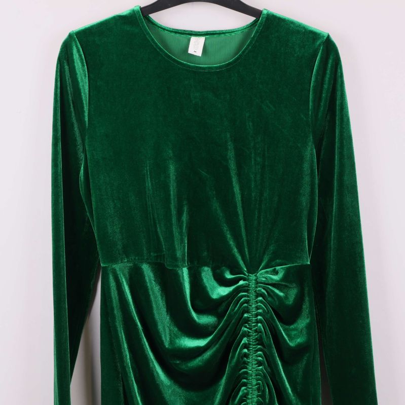Överdel och ärm på grön sammetsklänning med rund hals
