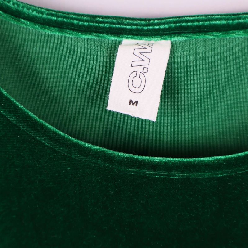 Närbild på etikett i halsringning med text C.W. och storlek M