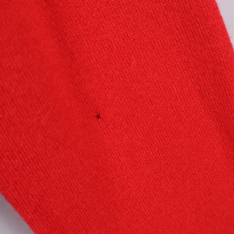 Detaljbild på mindre hål på ärmen