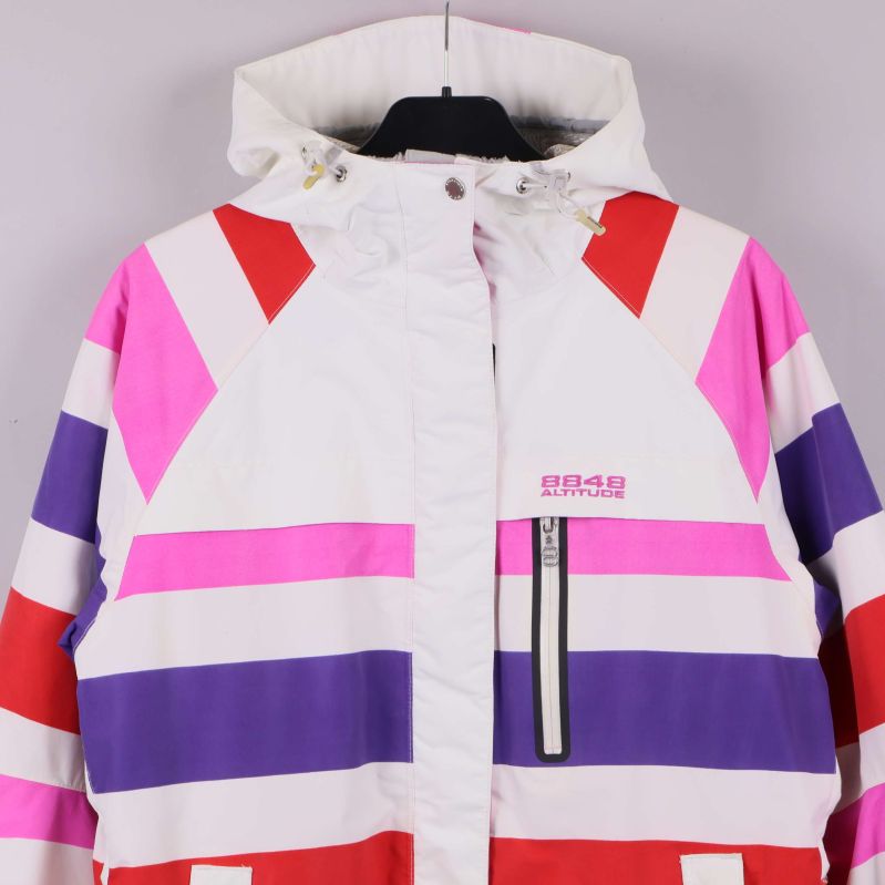 Jacka med fokus på överdelen, dragkedjor och märke synligt