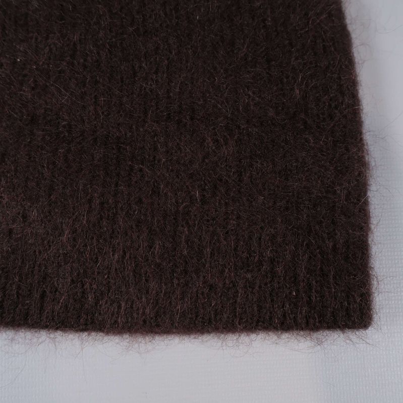 Närbild på den stickade ytan av brun mössa