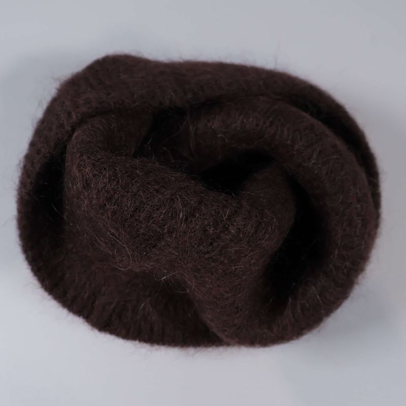 Brun mössa ihopvikt i en mjuk hög