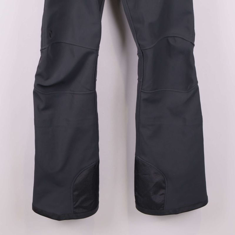 Närbild på förstärkta benslut på mörkgrå byxa