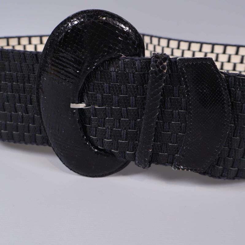 Närbild på bältets spänne och flätade detaljer