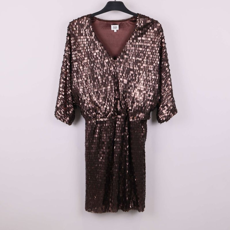 Framsida av paljettklänning på galge mot vit bakgrund