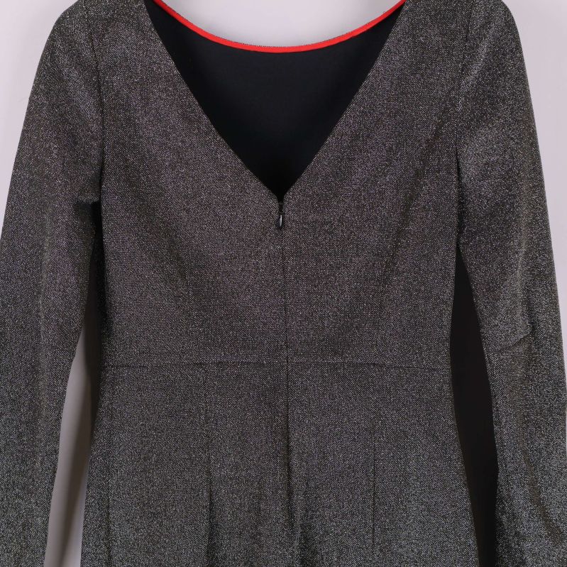 Baksida och dragkedja på glittrig långärmad klänning