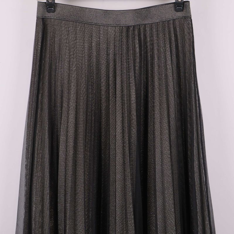 Närbild av plisserad kjol, glittereffekt tydligt synlig