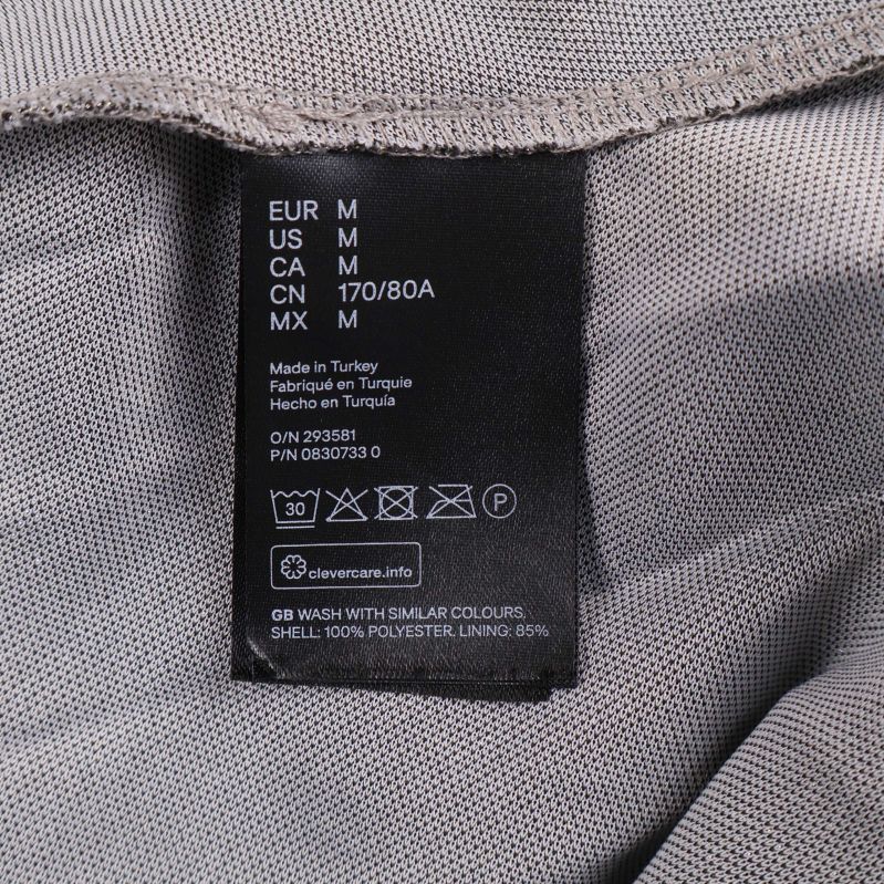 Materiallapp med information om 100% polyester och tvättråd